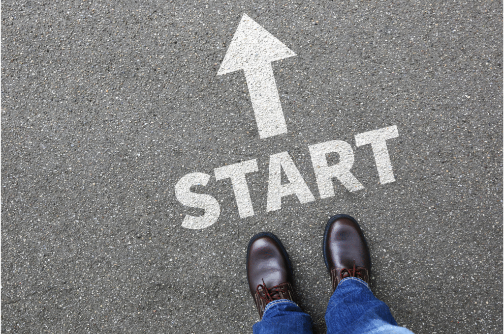 アスファルトに書かれた「START」の文字と矢印、その前に立つ足元